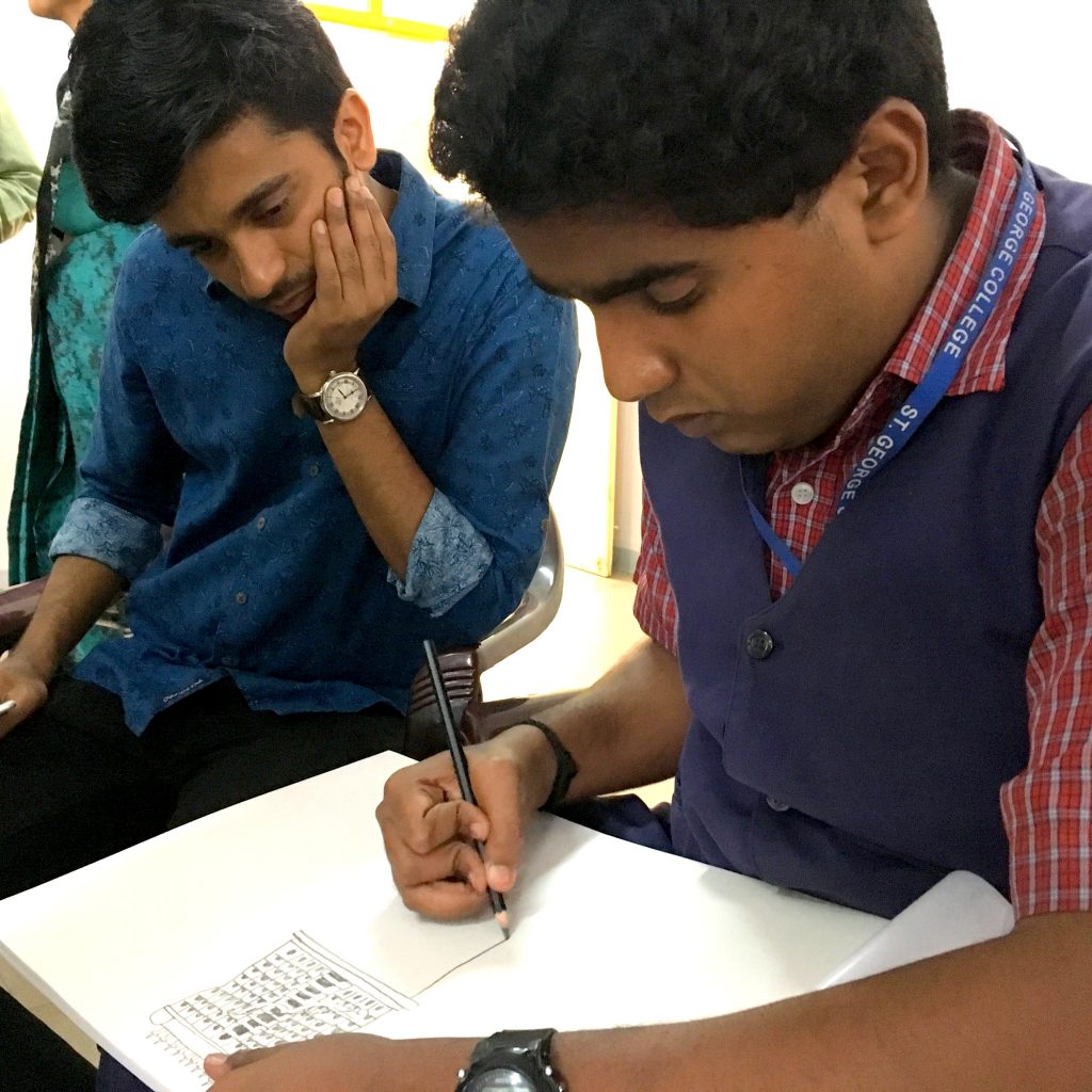 Pranav Varma drawing while Vilas Nayak watches